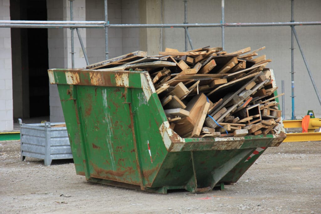 benne verte remplie de déchets en bois
